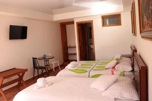 ChachagüíLa Gran Estancia Hotel Campestre的酒店客房设有三张床和一张桌子