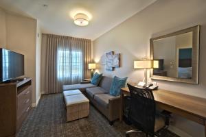 亨博尔Staybridge Suites Houston - Humble Beltway 8 E, an IHG Hotel的酒店客房设有沙发、书桌和电脑