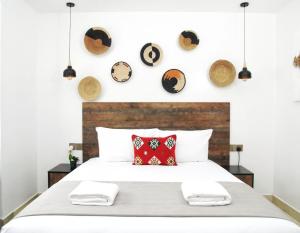 内罗毕Zendo Suite的卧室配有一张大床,墙上挂有枕头和盘子