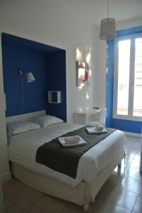 尼斯丹麦酒店的一间卧室配有一张带蓝色墙壁的大床