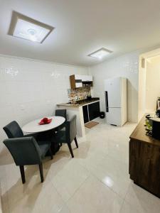 萨尔瓦多Apartamento lugar de Paz的厨房配有桌椅和冰箱。