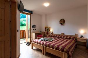 佩伊奥龙胆草木屋酒店的一间卧室设有一张床和一个滑动玻璃门