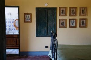 维克艾库塞Relais Villa Giusso的一间设有床铺的客房,墙上挂有图片