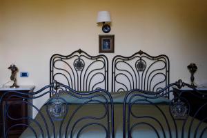 维克艾库塞Relais Villa Giusso的一间卧室设有两张床,墙上挂着一个时钟。