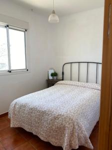 阿尔么丽亚Casa Alma的一间卧室配有一张带白色床罩的床和窗户。