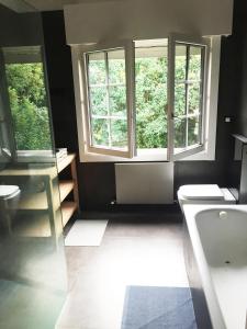 格乔Getxo Garden Houses - Grand Chalet的浴室设有2扇窗户、水槽和卫生间。