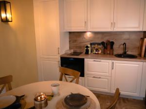 皮利什森特凯赖斯特Spirit of the Earth Cottage Dobogókő的厨房配有白色橱柜、桌子和水槽。