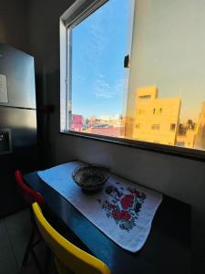 萨尔瓦多Apartamento encantador em salvador的窗边的桌子上放着碗