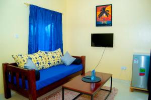 基利菲Magnolia Cosy 1 Bedroom Apartment-KILIFI的客厅配有蓝色的沙发和桌子