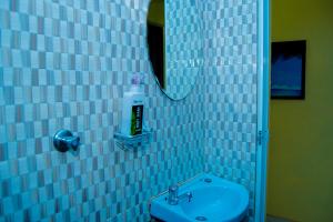 基利菲Magnolia Cosy 1 Bedroom Apartment-KILIFI的蓝色瓷砖浴室设有水槽和镜子