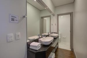 布卢梅瑙Slaviero Blumenau的一间带两个盥洗盆和大镜子的浴室