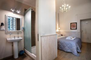 卢卡历史中心旅馆的浴室设有床和镜子旁的水槽