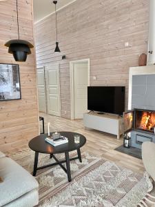 SuomusjärviVilla Laidike with sauna/fireplace, 80 km Helsinki的客厅配有桌子和壁炉