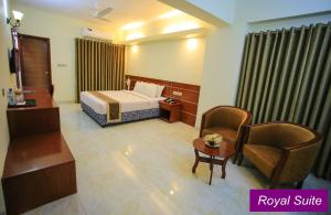 库克斯巴扎Royal Beach Resort的配有一张床和一把椅子的酒店客房