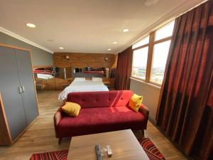 伊斯坦布尔HİLL SUİTES的一间卧室配有一张床和一张红色的沙发
