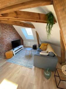加来Chez Mathilde Studio Calais Nord Citadelle的带沙发和电视的客厅
