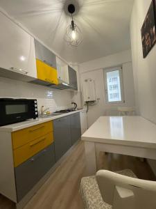 雅西Luxury Q Residence Near Center的厨房配有白色的柜台和黄色的橱柜