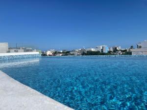 普拉亚卡门WINDAY HOTEL - Cerca 5a Avenida的蓝色的海水游泳池,以城市为背景