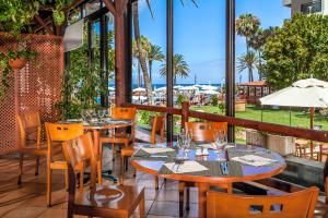 美洲海滩索尔特内里费岛酒店的一间带桌椅的海景餐厅