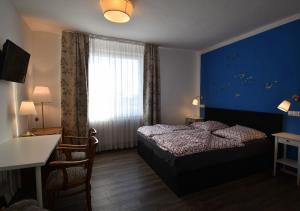 达默Hotel Sonnenschein - Spielerei im Sonnenschein的一间卧室设有一张床和蓝色的墙壁