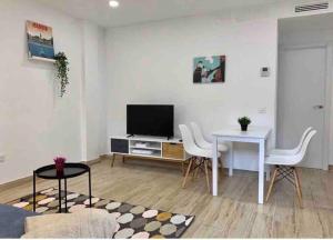 马德里Apartamento 4 personas的客厅配有电视和桌椅