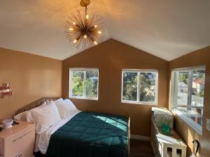洛杉矶Glamping Hollywood Hills - Luxury Tiny House的一间卧室配有一张床、窗户和吊灯