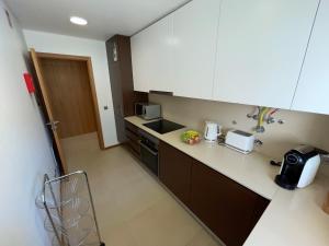 阿尔布费拉Albufeira Lux Apartment的一个带柜台和水槽的小厨房