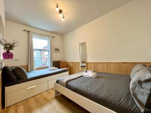 魁北克市Les 300s 3e Avenue的卧室配有床、椅子和窗户。