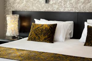 纳尔逊纳尔逊扬帆酒店的一张带黑色床头板、枕头和灯的床