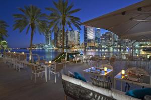 迈阿密Mandarin Oriental, Miami的一间设有桌椅的餐厅,享有城市美景