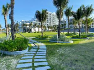 金兰市Seaview Arena Cam Ranh Nha Trang hotel near the airport的棕榈树公园和建筑中的步道