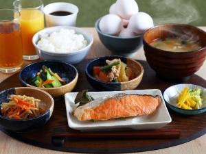 名古屋Henn na Hotel Express Nagoya Fushimi Ekimae的木桌,放着一碗食物和一盘鱼