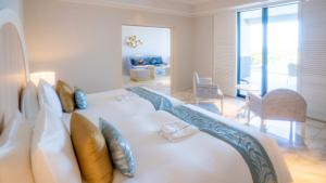 宫古岛Miyakojima Kurima Resort Seawood Hotel的客厅配有带枕头的大白色沙发