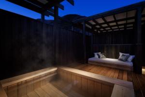 箱根Hotel Zagakukan的夜间木甲板上设有2张床的门廊