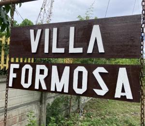 邦劳Villa Formosa Panglao的挂在链上的标志,上面写着别墅的特许权