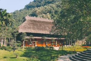 宁平Thung Nham Resort的茅草屋顶和楼梯的房子