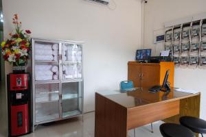 马格朗RedDoorz near Alun Alun Magelang 2的办公室设有书桌和冰箱
