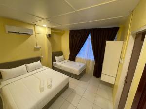 哥打巴鲁Hotel Sri Maju Jaya的一间小卧室,配有两张床和窗户