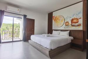 Ban Nua Khlongโรงแรมชลาลัย กระบี่ Chalalai Hotel Krabi的一间卧室设有一张大床和一个大窗户