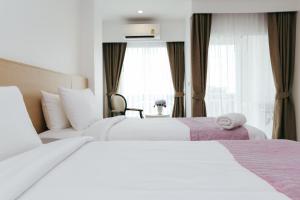 清迈Arsh Boutique Hotel的酒店客房设有两张床和窗户。