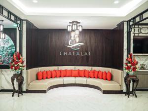 Ban Nua Khlongโรงแรมชลาลัย กระบี่ Chalalai Hotel Krabi的墙上的白色沙发,上面有红色枕头