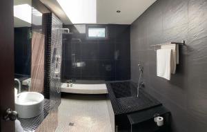 Ban Thong PhluVilla Mandi的黑色浴室设有浴缸和水槽