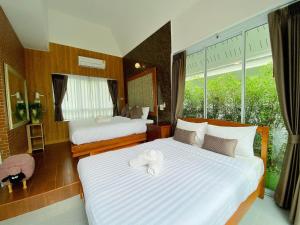 清刊ภูฝ้ายวิลล่า Phufai villa的酒店客房设有两张床和窗户。