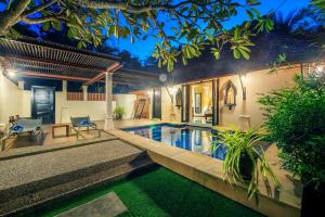 高兰Chada Lanta Beach Resort - SHA Extra Plus的夜间带游泳池的别墅