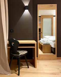福尔加里亚Hotel Rech-Hof Sayonara的一间卧室配有一张桌子和一张椅子,位于床边