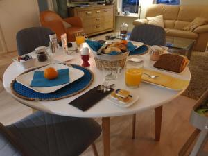 WilpBij de oude dijk的一张带早餐食品和橙汁的白色桌子