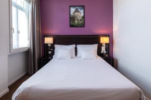 梅斯蒙东酒店的卧室配有一张白色大床和紫色墙壁