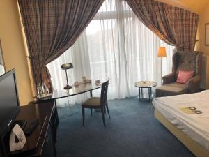 费尔登霍尔野艾克森特酒店的酒店客房配有一张床、一张桌子和一把椅子。