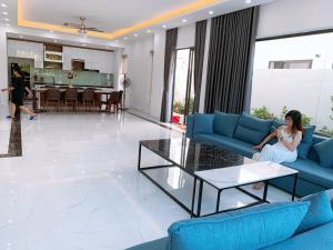 岑山Villa FLC Sầm Sơn Vị Trí Trung Tâm View Biển的坐在客厅沙发上的女人