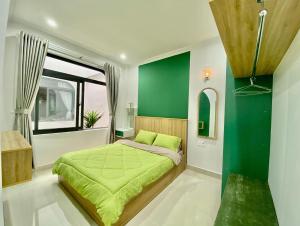 保禄SÂM LÂM HOUSE - Bảo Lộc的一间卧室设有一张绿色的床和一个窗户。